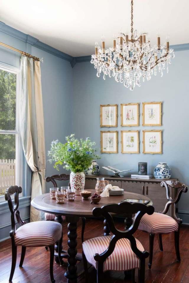 The Blue Dining Room with crystal chandelier and botanical prints in gold frames