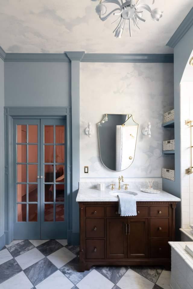 Blue bathroom with arched tub alcove and brass fixtures