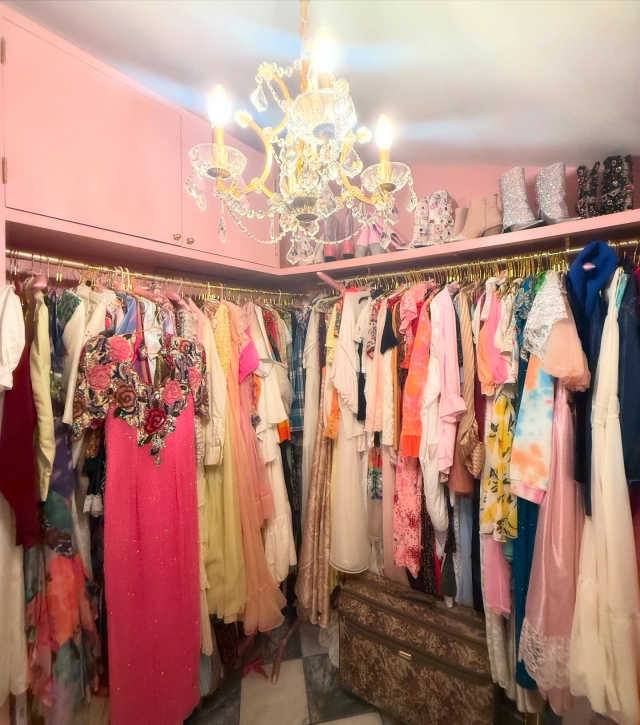 Pink dressing room with chandelier and vintage gowns