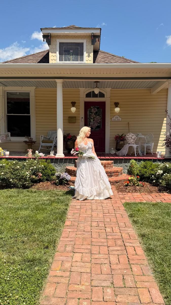 Claire in a vintage gown on the brick path in front of Claire's Chateau