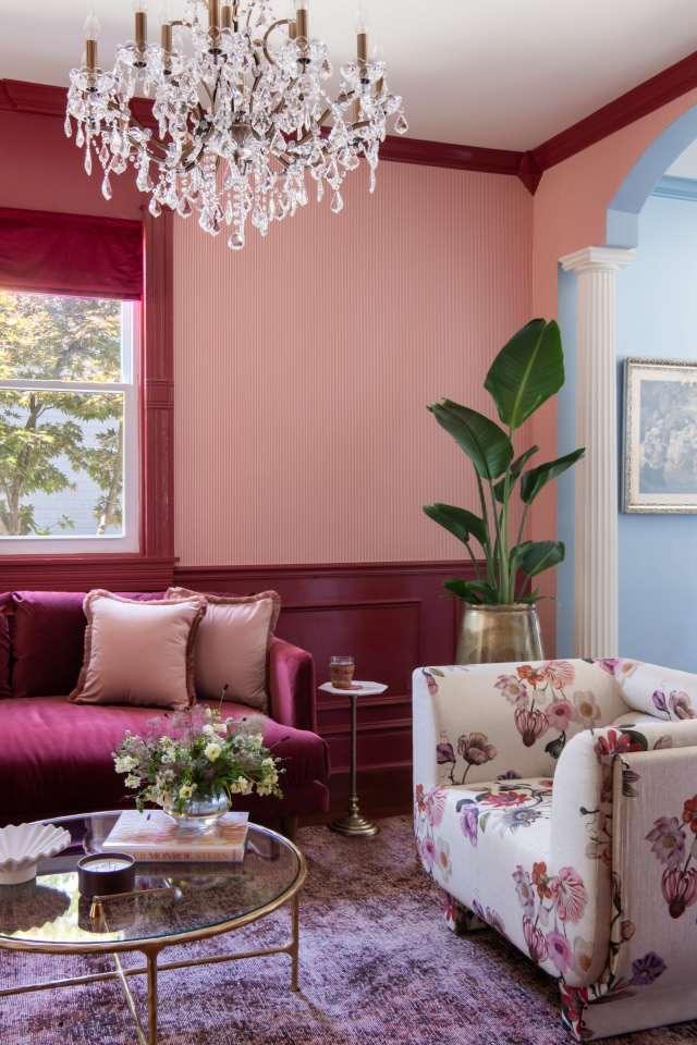 The Parlour, with a crimson velvet sofa, floral armchair, and crystal chandelier